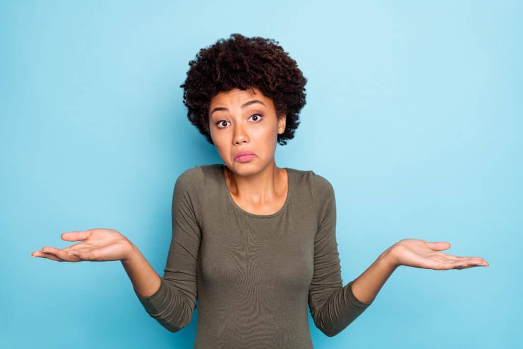 Portrait of a woman looking unsure and confused while trying to make a decision.