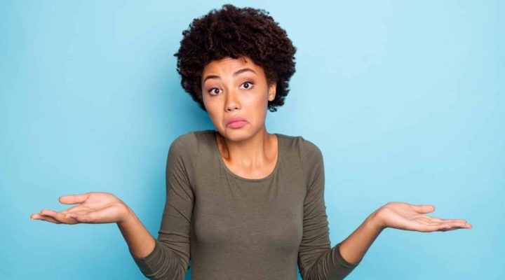 Portrait of a woman looking unsure and confused while trying to make a decision.