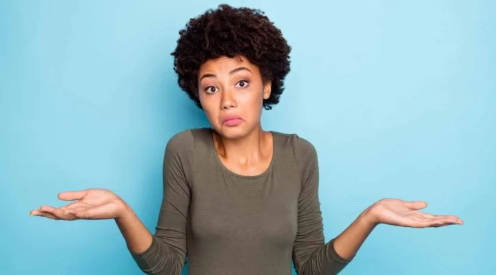 Portrait of a woman looking unsure and confused while trying to make a decision.