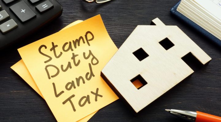 Desk with post-it note with Stamp Duty Land Tax written on it.