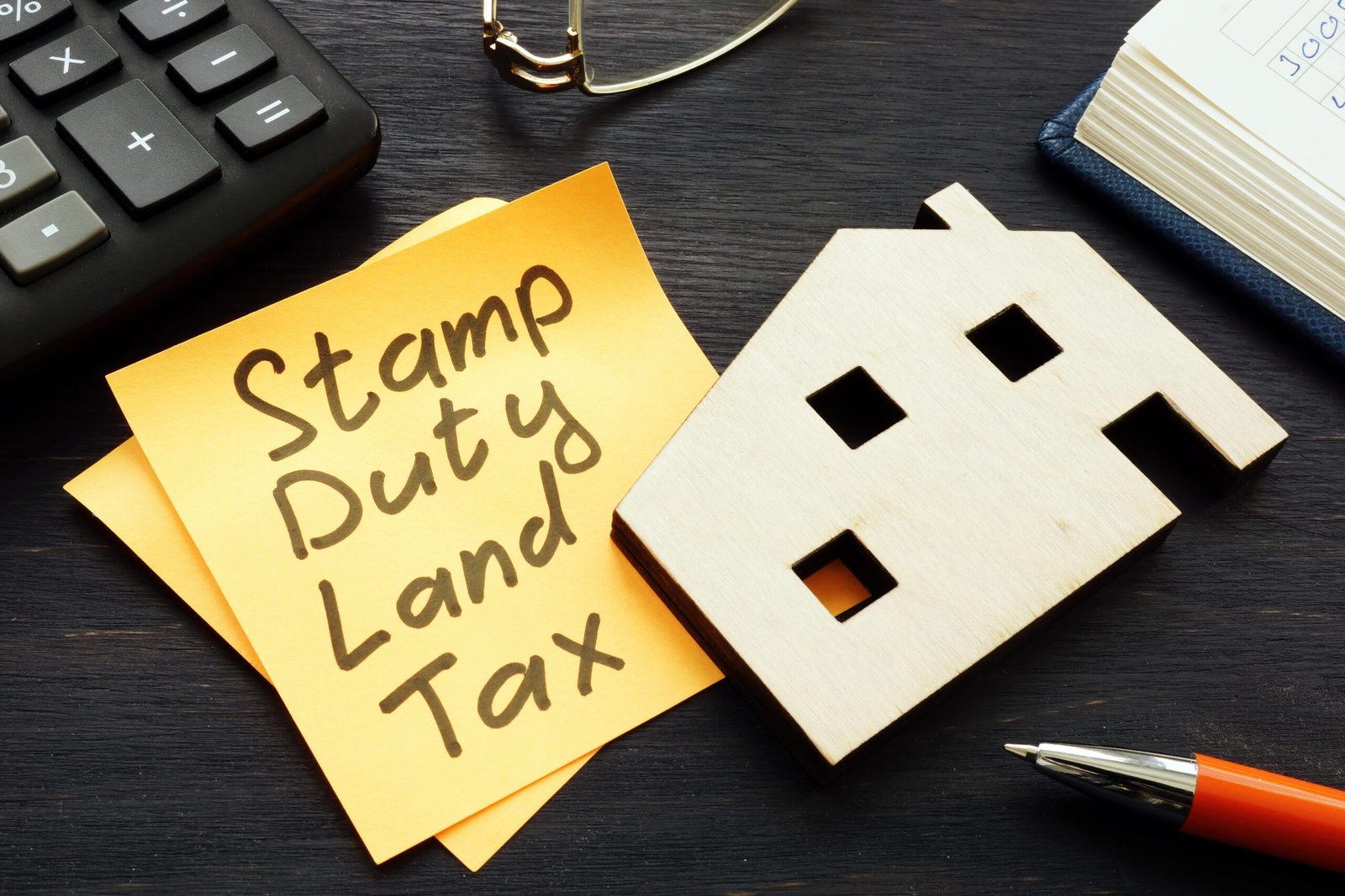 Desk with post-it note with Stamp Duty Land Tax written on it.