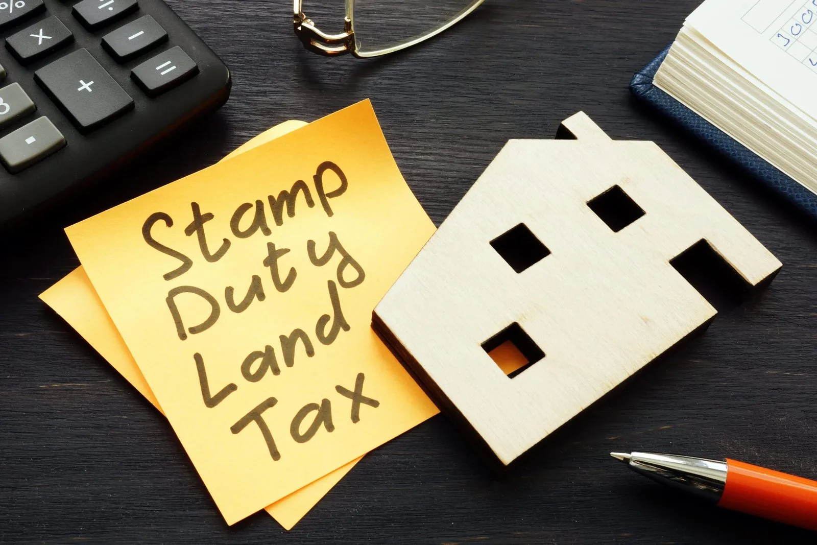 Desk with post-it note with Stamp Duty Land Tax written on it.