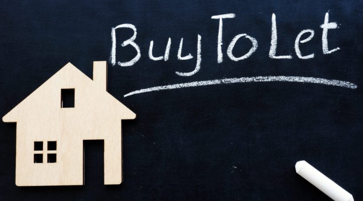 Blackboard with a wooden house and Buy to Let written in chalk