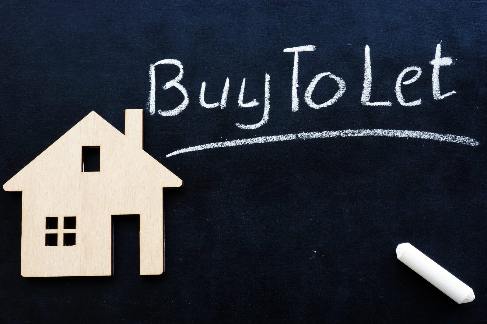 Blackboard with a wooden house and Buy to Let written in chalk